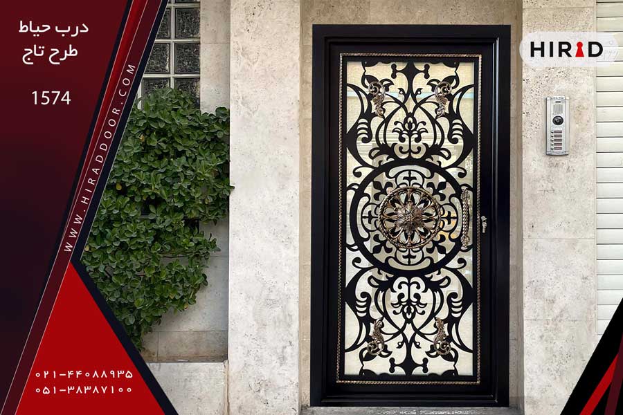 درب حیاط تک لنگه مشکی رنگ با طراحی بسیار زیبا با قاب طلایی، قطعات تزئینی چدنی و دستگیره چدنی، نصب شده در ورودی ساختمان جنوبی